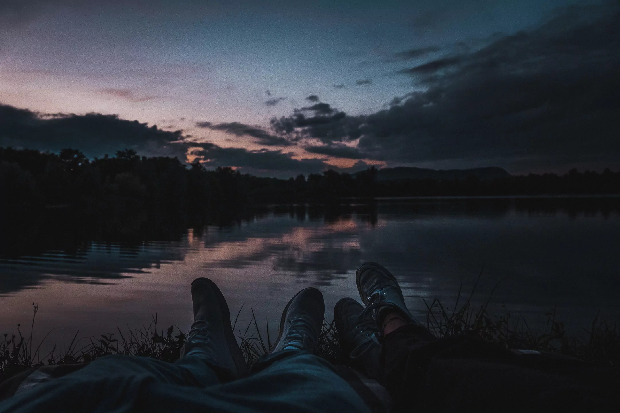 two people laying at a lake
